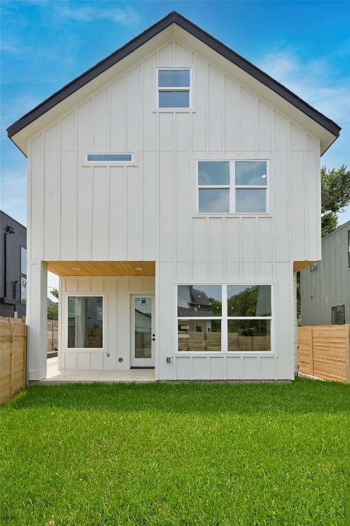 back of property with a patio area and a lawn