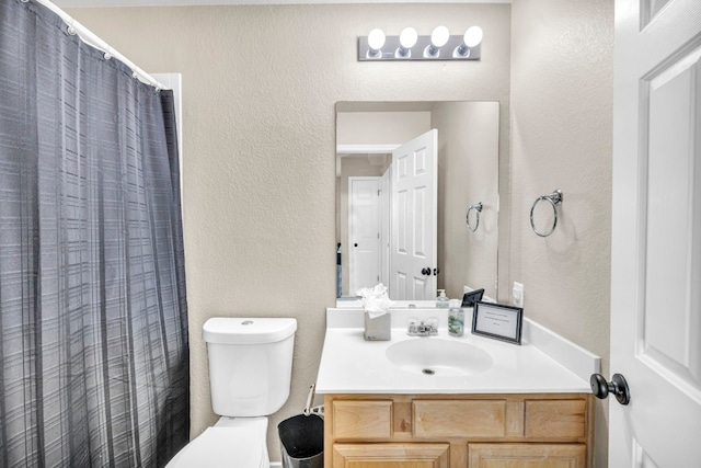 full bathroom featuring toilet, a textured wall, curtained shower, and vanity