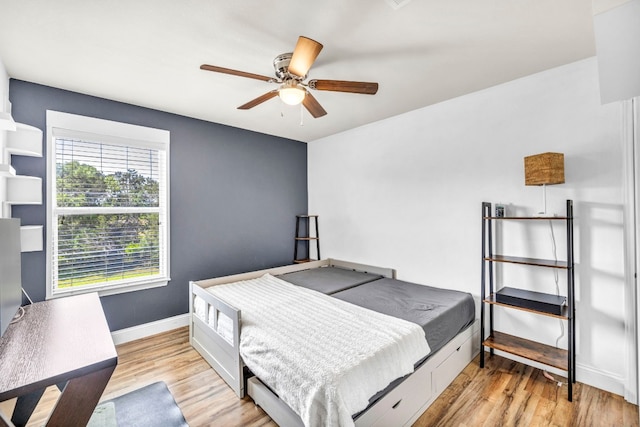 bedroom with a ceiling fan, baseboards, and wood finished floors