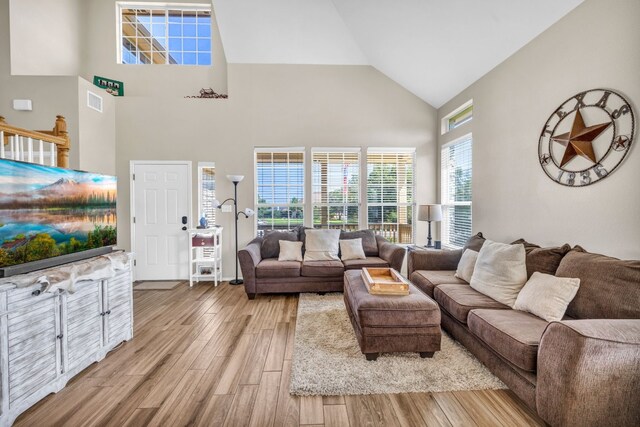 living room with high vaulted ceiling and hardwood / wood-style floors