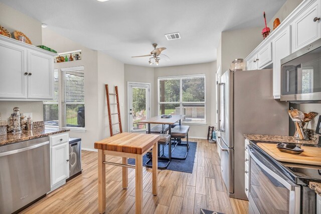 kitchen featuring white cabinetry, stainless steel appliances, light hardwood / wood-style flooring, and ceiling fan