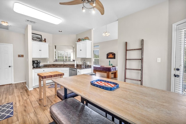 kitchen featuring light wood finished floors, dark countertops, visible vents, white cabinets, and dishwasher