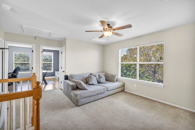 living room with light carpet, a healthy amount of sunlight, and ceiling fan