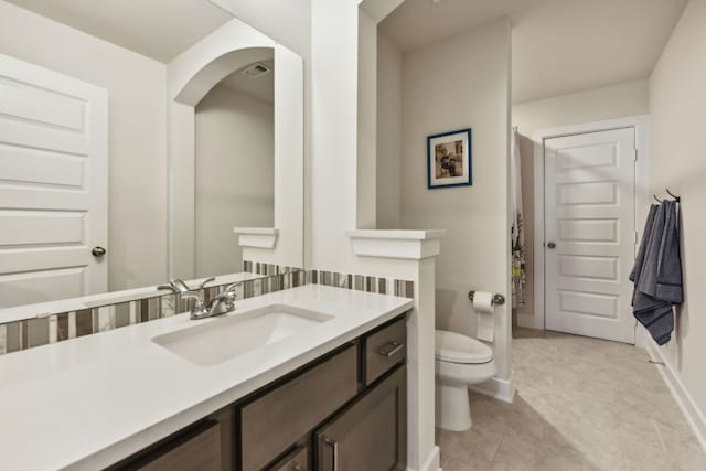 bathroom with vanity, tile patterned flooring, and toilet