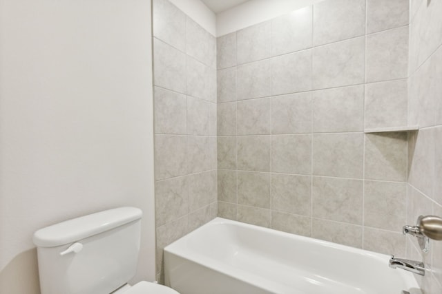 bathroom featuring tiled shower / bath combo and toilet