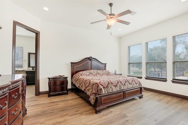 bedroom with multiple windows and light hardwood / wood-style flooring