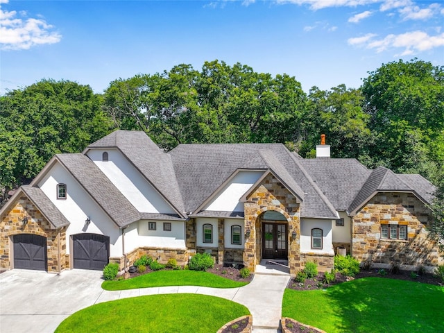 view of front of house with a front lawn, french doors, and a garage