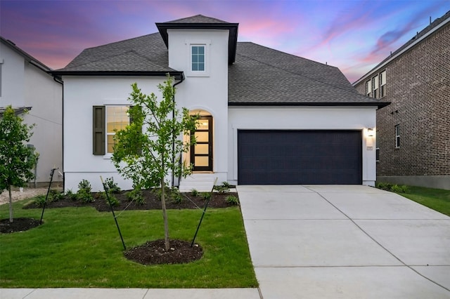 view of front of house with a garage and a yard