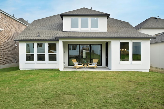 rear view of property featuring a lawn and a patio