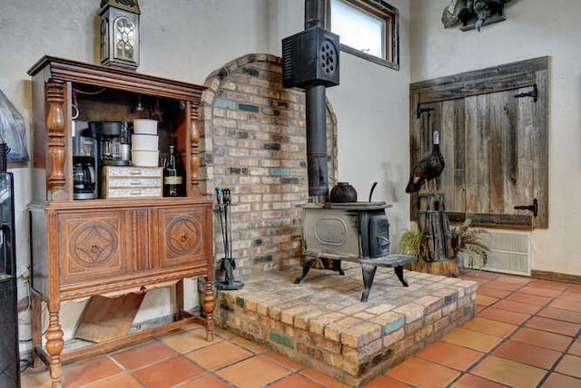 living room with tile flooring and a wood stove