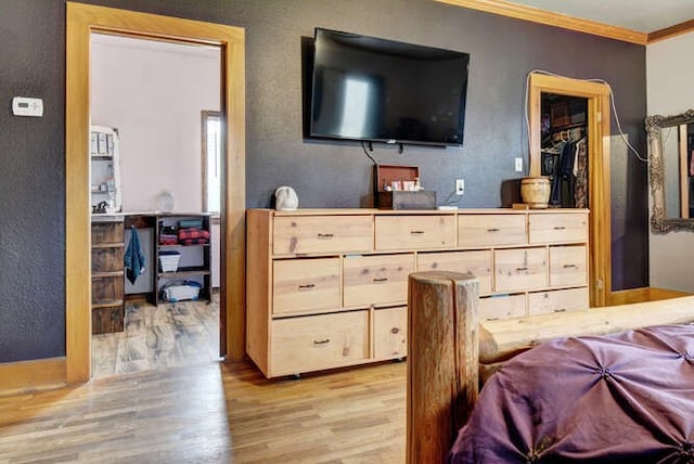 bedroom featuring crown molding and light hardwood / wood-style flooring