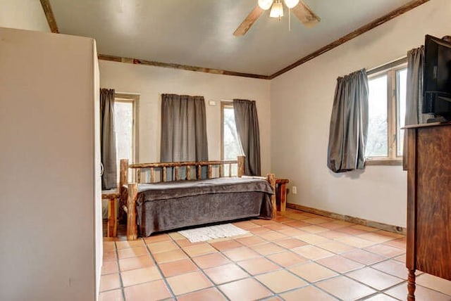 tiled bedroom with ornamental molding and ceiling fan