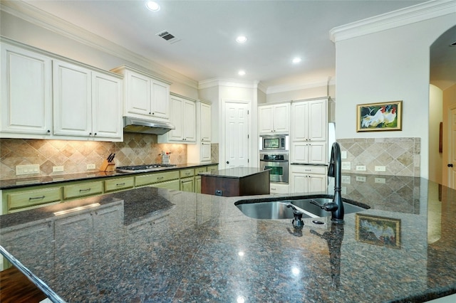 kitchen with backsplash, white cabinets, sink, dark stone countertops, and appliances with stainless steel finishes