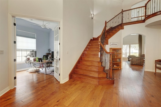 staircase with hardwood / wood-style floors, a wealth of natural light, and french doors