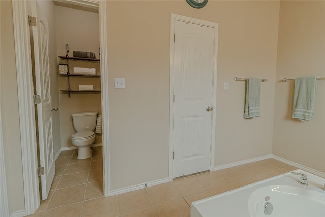 bathroom with tile floors, a washtub, and toilet