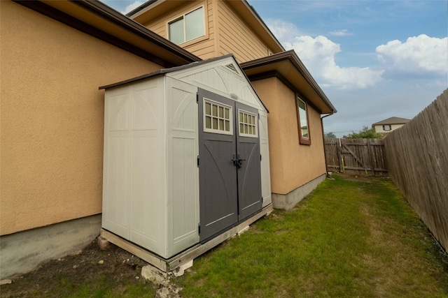 view of property exterior featuring a storage shed and a yard