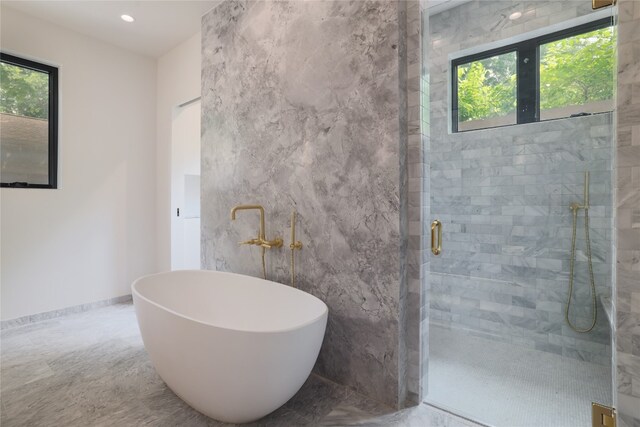 bathroom with tile walls, tile floors, a wealth of natural light, and an enclosed shower