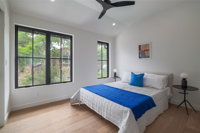 bedroom featuring vaulted ceiling, ceiling fan, and light wood-type flooring