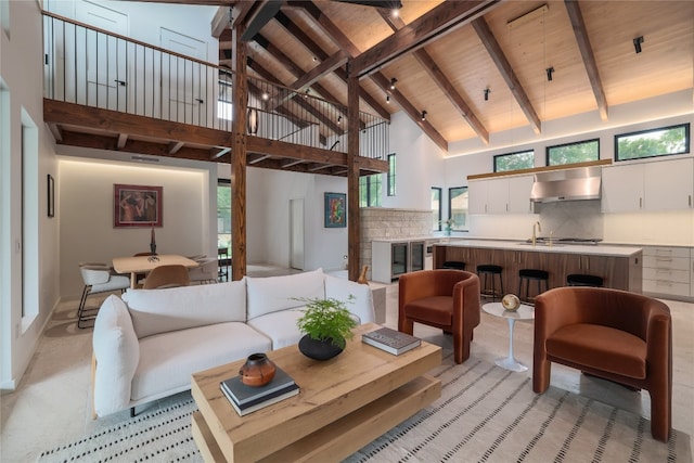 living room with beam ceiling, high vaulted ceiling, and plenty of natural light