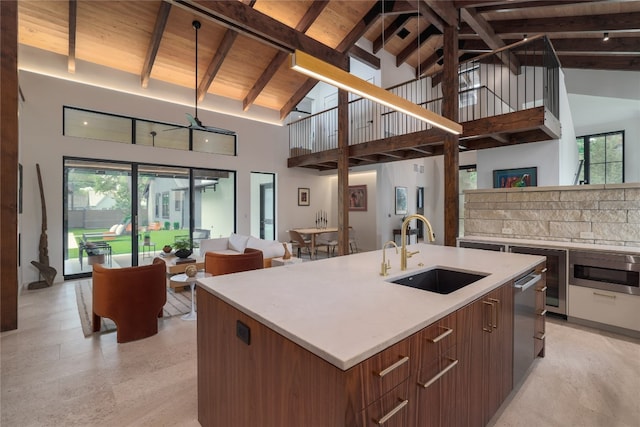 kitchen featuring beam ceiling, wooden ceiling, sink, and a wealth of natural light