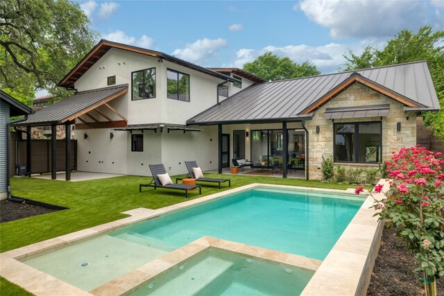 back of house featuring a patio, a swimming pool with hot tub, and a lawn