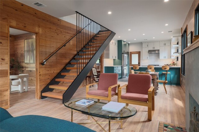 living room with wood walls and light wood-type flooring