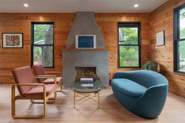 living room featuring a premium fireplace, hardwood / wood-style flooring, and wood walls