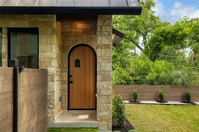 property entrance with a lawn