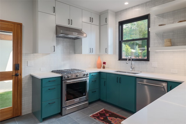 kitchen with white cabinets, dark tile floors, tasteful backsplash, and appliances with stainless steel finishes