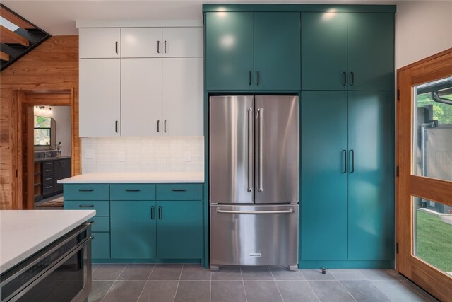 kitchen with white cabinetry, high end fridge, wine cooler, tasteful backsplash, and dark tile floors