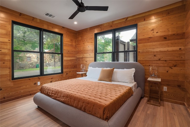 bedroom featuring wood-type flooring, ceiling fan, and multiple windows