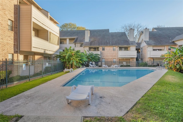 view of pool with a patio area and a yard