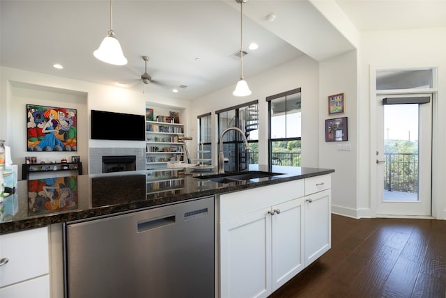 kitchen with sink, white cabinets, a wealth of natural light, and a brick fireplace