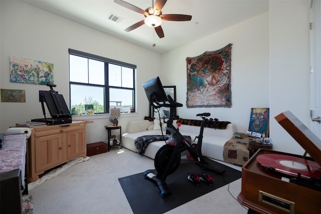 workout area with ceiling fan and light colored carpet