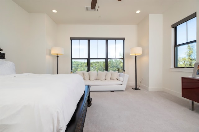 carpeted bedroom featuring multiple windows and ceiling fan