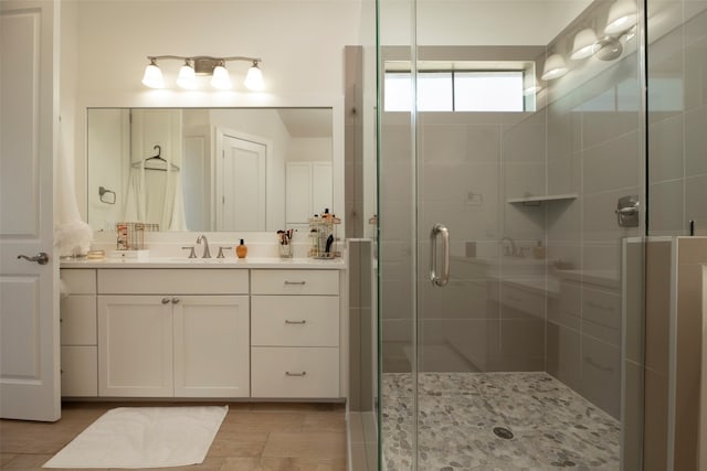 bathroom featuring a shower with shower door and vanity