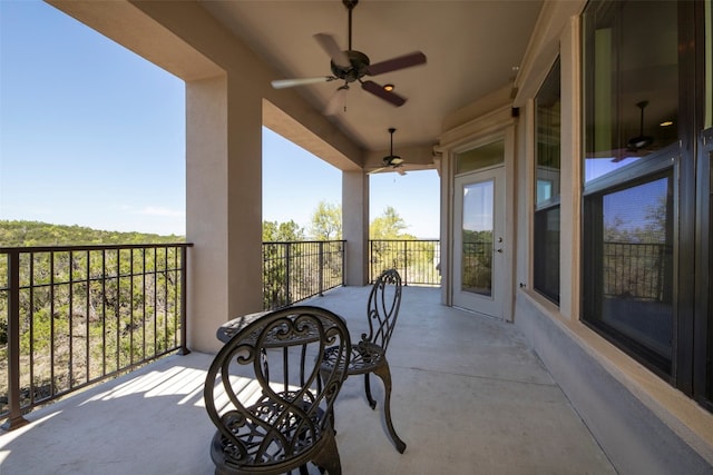 view of patio with ceiling fan and a balcony