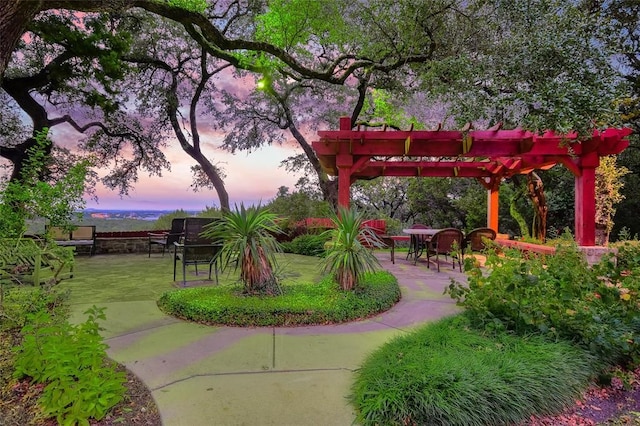 view of property's community featuring a yard, a pergola, and a patio