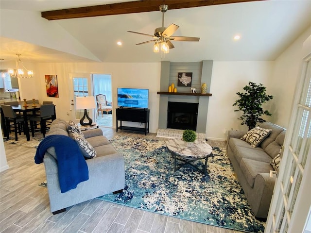 living room featuring lofted ceiling with beams, light hardwood / wood-style floors, and ceiling fan with notable chandelier