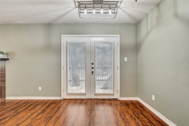 entryway featuring a textured ceiling, dark wood-type flooring, and french doors