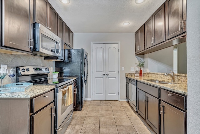 kitchen with light tile patterned flooring, appliances with stainless steel finishes, dark brown cabinets, and sink