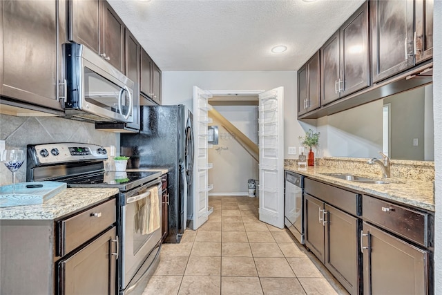 kitchen featuring light tile patterned flooring, sink, dark brown cabinetry, and stainless steel appliances