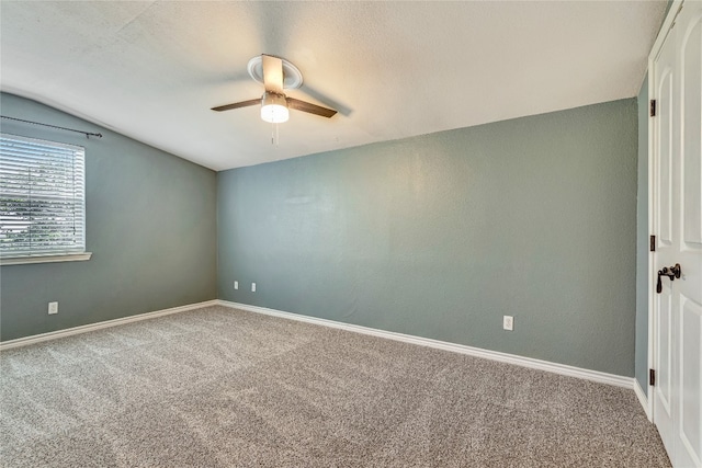 empty room featuring carpet, ceiling fan, and lofted ceiling