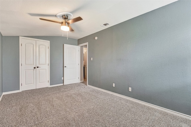 unfurnished bedroom featuring carpet floors, vaulted ceiling, and ceiling fan