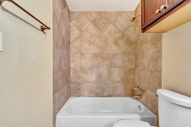 bathroom with tiled shower / bath combo and toilet