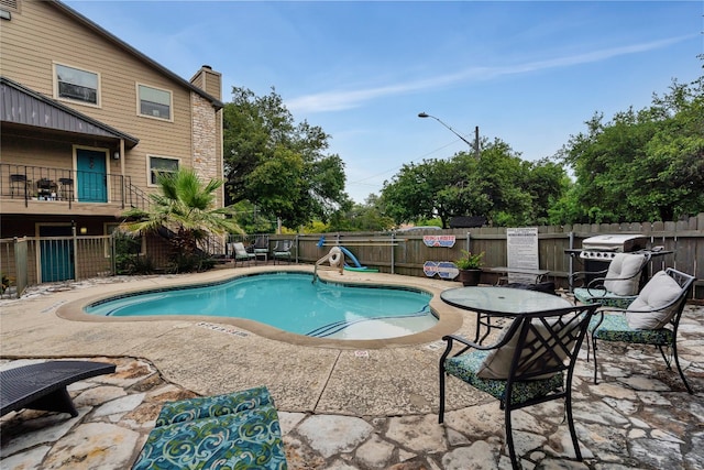 view of swimming pool with a grill and a patio area