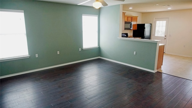 interior space featuring black refrigerator, ceiling fan, dark hardwood / wood-style floors, and range