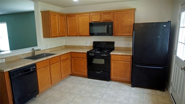 kitchen featuring sink, black appliances, and light tile floors