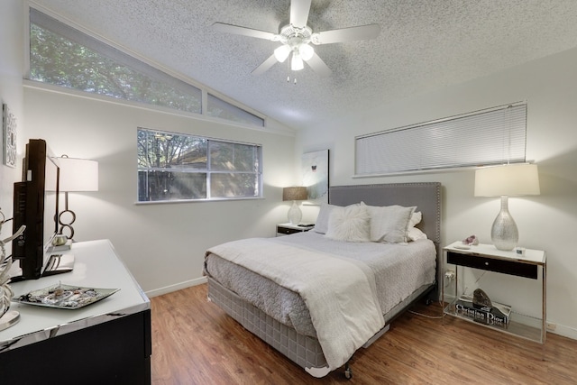 bedroom with ceiling fan, a textured ceiling, lofted ceiling, and wood-type flooring