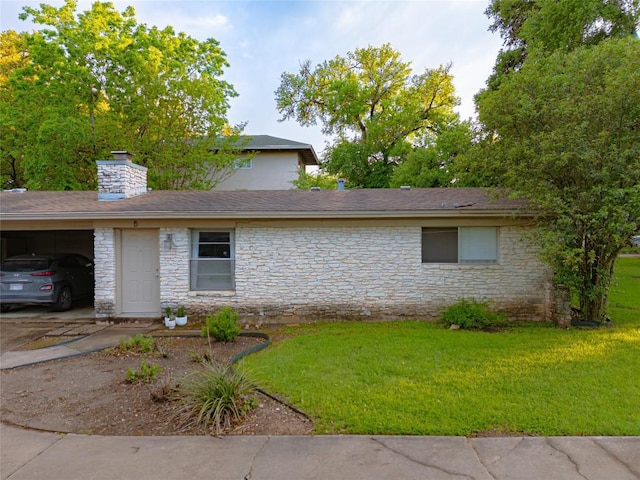 view of front of home with a carport and a front lawn